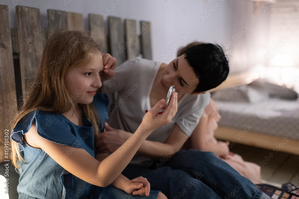 Mother teaching glad daughter to apply makeup Mother teaching glad daughter to apply makeup
