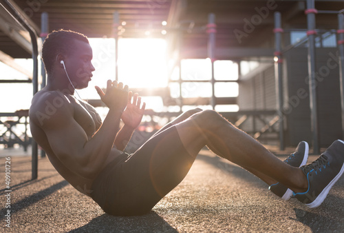 Strong black man doing abdominal exercises photo