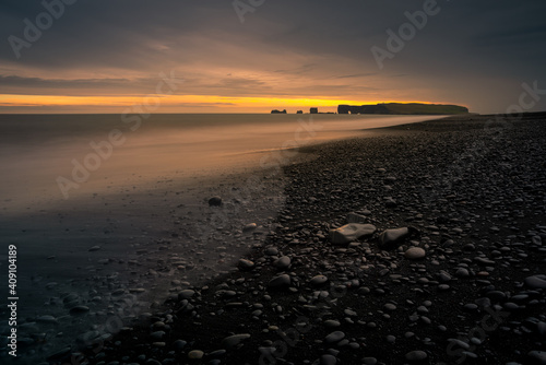 Sunset over the Dyrholaey peninsula as seen from the black beach of Reynisfjara