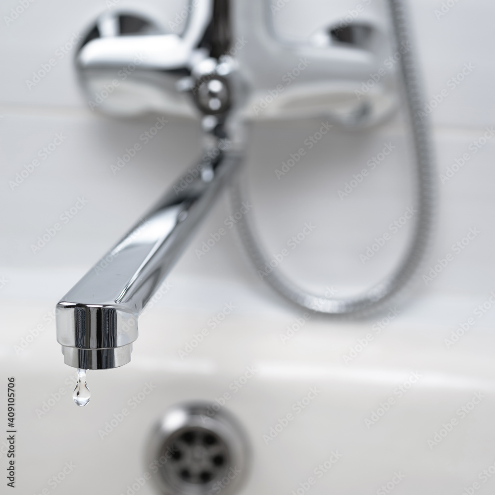 A drop of pure water dripping from the tap. Selective focus. A drop of pure water dripping from the tap. Selective focus.