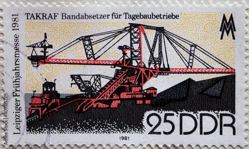 GERMANY, DDR - CIRCA 1981 : a postage stamp from Germany, GDR showing a TAKRAF, belt stacker for opencast lignite mining operations. Leipzig Spring Fair photo