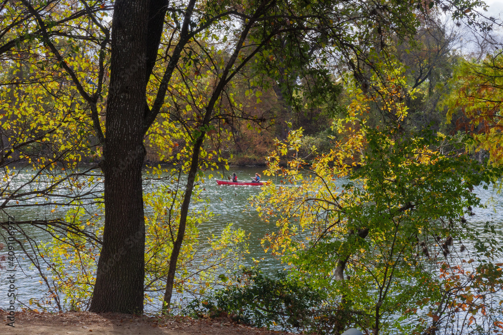 Red canoe on lake through foliage