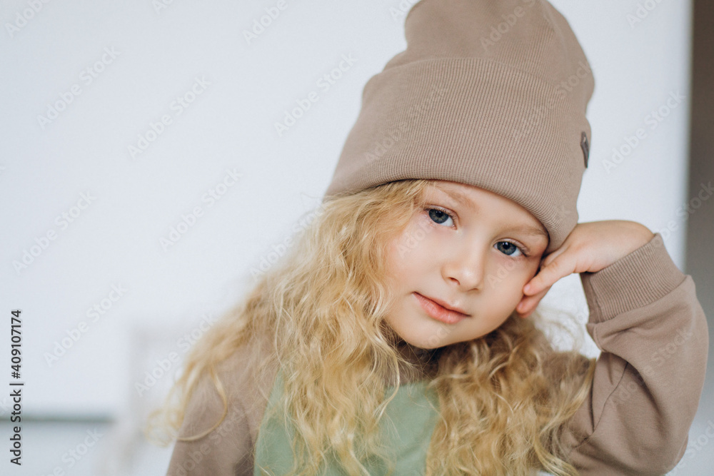 Cheerful adorable curly blondie girl on isolated background. Stylish expressive emotional kid portrait Cheerful adorable curly blondie girl on isolated background. Stylish expressive emotional kid portrait