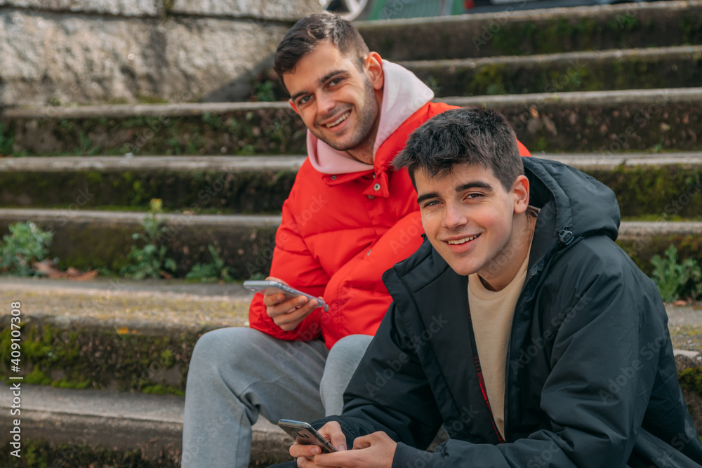 young people having fun with mobile phones on the stairs of the city street young people having fun with mobile phones on the stairs of the city street