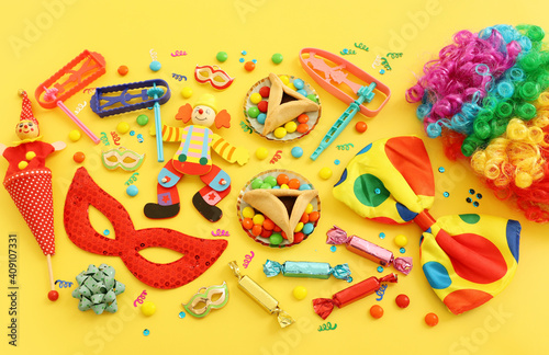 Purim celebration concept (jewish carnival holiday) over yellow background. Top view, flat lay