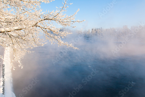 Fog winter landscape on the river Fabulous misty view of lake Frosty morning. Cold weather background concept. Abstract minimalistic picture. Christmas and New Year holiday greeting card © Maria Petrish