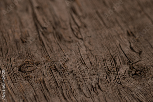 Dark brown textured wooden background with a knot