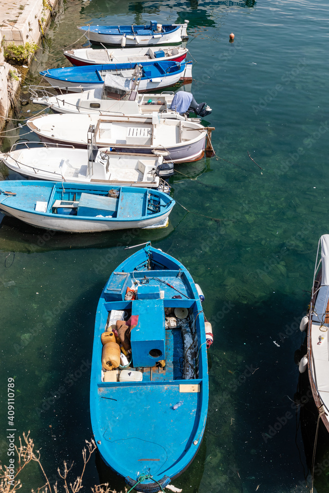 Light blue fishing boat in the harbor of the old town of Gallipoli, Puglia, Italy - Europe