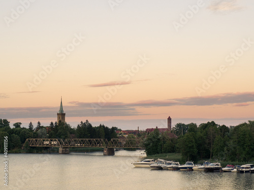 Fototapeta Naklejka Na Ścianę i Meble -  Mikołajki, Masuria, Poland, 30. July 2020. Railway bridge and mikolajki churche towers. Talty lake.