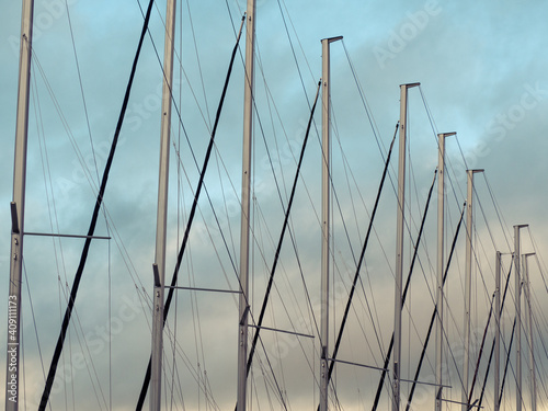 Fototapeta Naklejka Na Ścianę i Meble -  Row of yacht mainsails and lines. Cloudy sky.