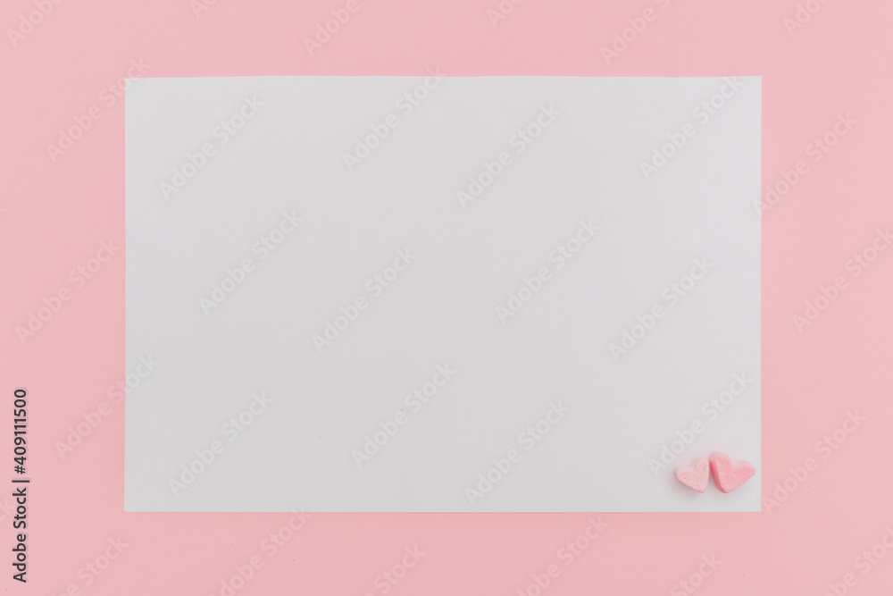 closed blank pearlescente envelope with paper heart on the pink background