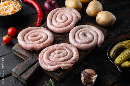 Raw meat sausage, on old dark wooden table background
