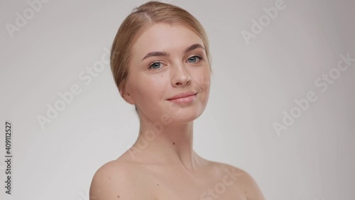 Beauty portrait of an attractive smiling sensual young woman. Close up. Adorable young half-naked woman look at the camera and smiling. Advertising fresh clean healthy skin care concept.