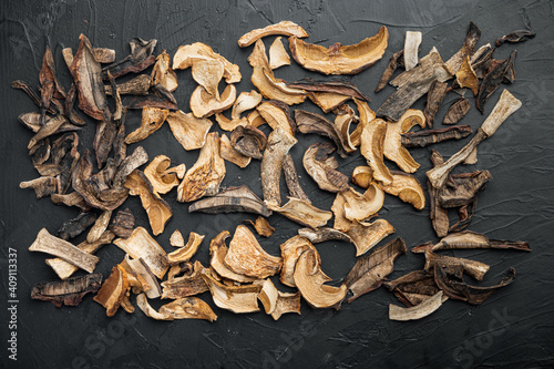 Dried mushrooms, on black background, top view flat lay