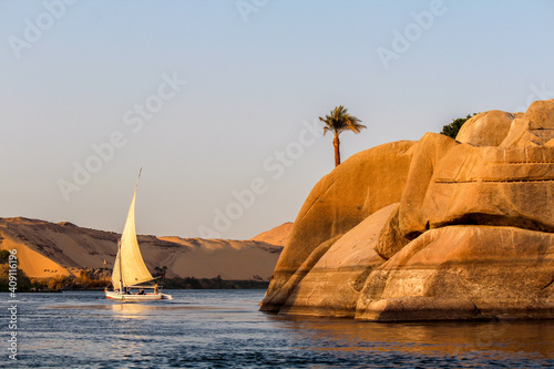 Sailboat on the Nile river at sunset, rock with ancient carvings in the front photo
