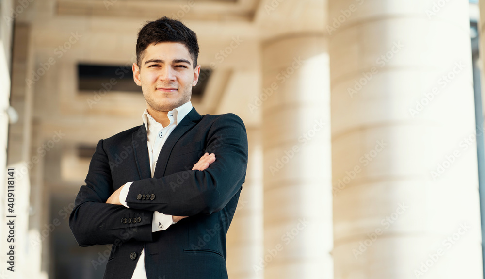 Fototapeta premium a man in a black business suit and white shirt looks at the camera. works in a bank in the city center. Dark-haired appearance. Sunny Light is a confident director of the finance department.