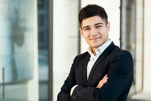the satisfied professional financier manager smiles and looks at the camera. He is dressed in a black business suit and a white shirt. the man has an Arab appearance of ethnic origin.