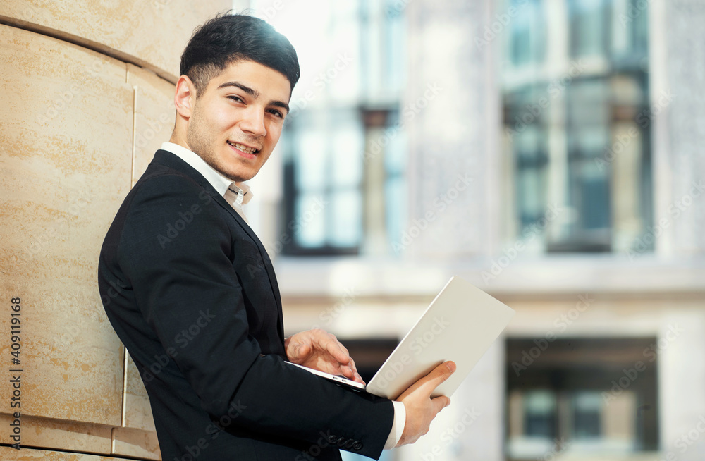 Prints a text to its director about the work done on the project. an Arab-looking businessman works on a laptop computer in a black business suit. Prints a text to its director about the work done on the project. an Arab-looking businessman works on a laptop computer in a black business suit.