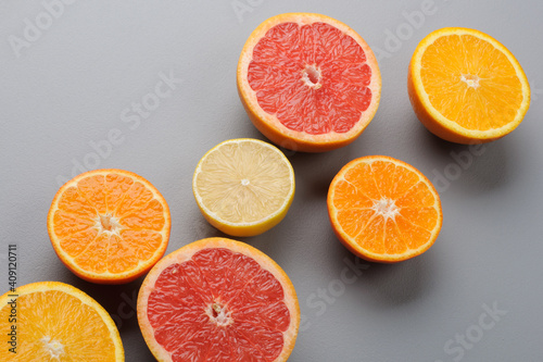 Cut in half fresh citrus fruits on gray background. Citrus juice ingredients  food background