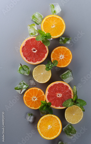 Creatively laid out citrus fruits on gray background. Top view of oranges  lemons  tangerines  grapefruit.Preparation of drinks. Citrus juice ingredients  food background