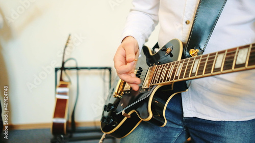 Close up of man playing guitar. Concert with a band