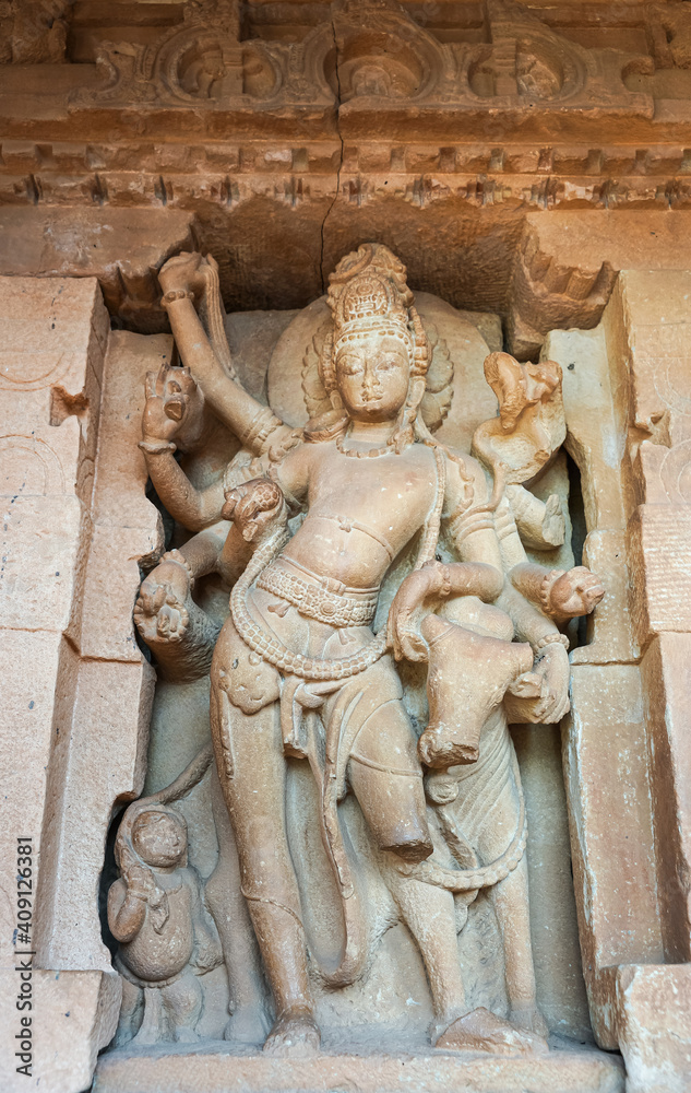 Aihole, Karnataka, India - November 7, 2013: Durga Gudi or Temple. Beige-brown stone massive statue of Shiva leaning on nandi.