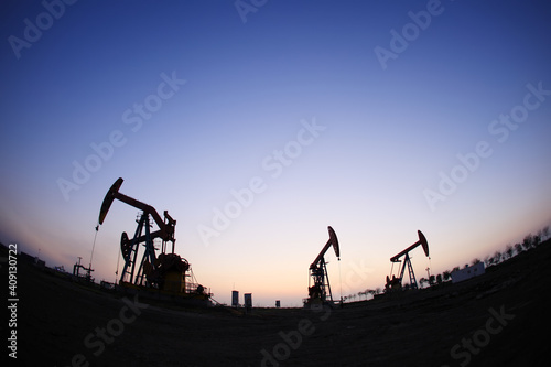  the oil pump in the evening, the evening silhouette of the pumping unit, the silhouette of the oil pump © zhengzaishanchu