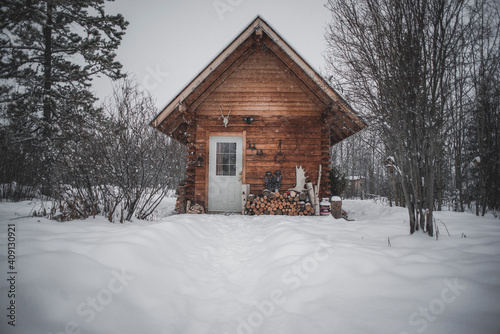 A wooden cabin in a snowy winter landscape © Peter