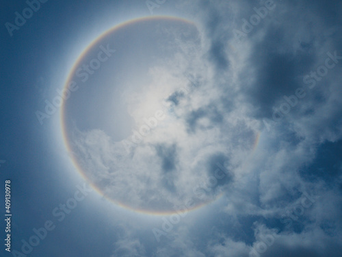 Solar Halo Also known as a 22-degree halo or a sun halo  with the sun in the center of ring is caused by sunlight passing through ice crystals in cirrus clouds within the Earth s atmosphere.