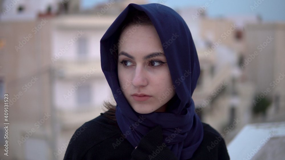 Young woman in arab shawl. A woman is looking at the camera. On the roof of the house against the backdrop of Arab houses. Young woman in arab shawl. A woman is looking at the camera. On the roof of the house against the backdrop of Arab houses.