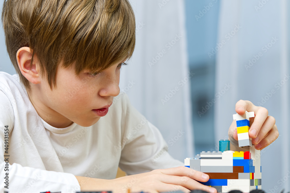 young boy playing with plastic construction toys at home. young boy playing with plastic construction toys at home.