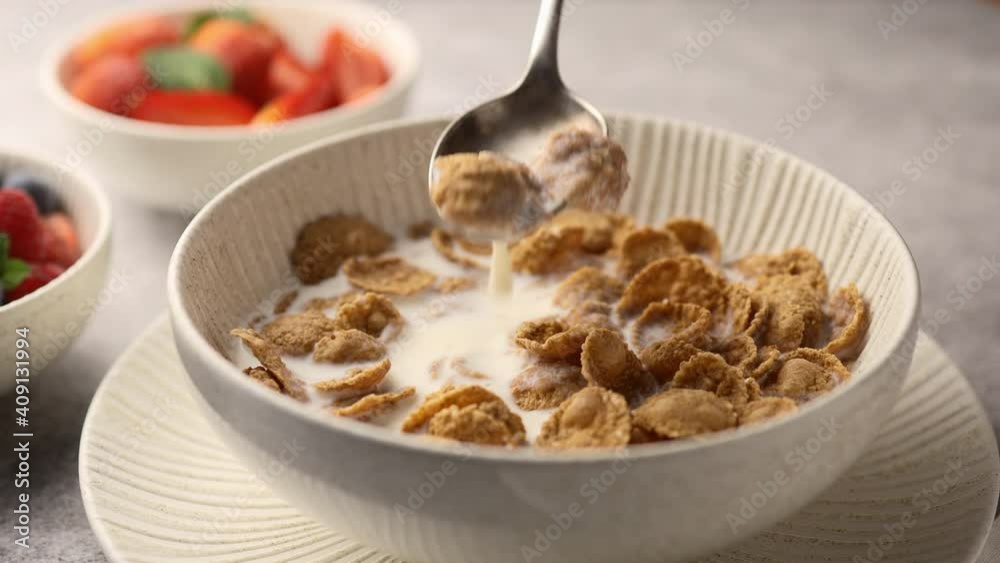 Girl takes multi-grain cereal from a bowl with a spoon, breakfast, close-up Girl takes multi-grain cereal from a bowl with a spoon, breakfast, close-up