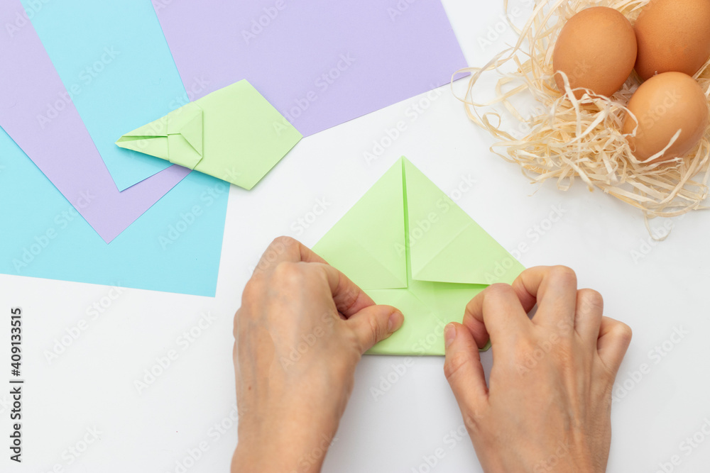 DIY Children's Easter craft bunny with an egg. Easter paper step by step instructions. Step 13. Happy bunny holds egg. Children's Art Project, needlework, crafts for children, springtime.