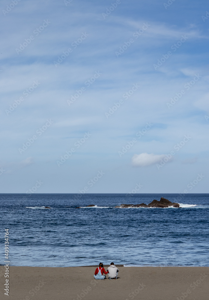 Two people sitting on beach, lovers enjoying, good weather, Azores, Sao Miguel. Two people sitting on beach, lovers enjoying, good weather, Azores, Sao Miguel.