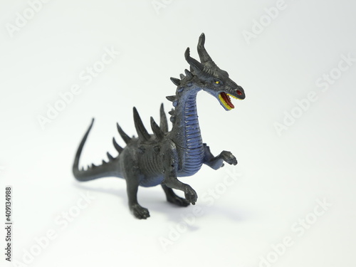 Horned dragon throws fire. Evil monster. Angry and bad dragon. Toy for children. Plastic toy.