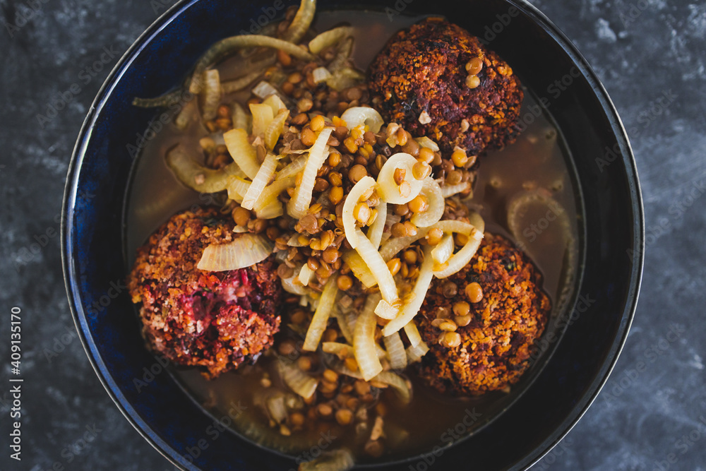 plant-based food, vegan crumbed beetroot patties in savoury broth with onion and lentils
