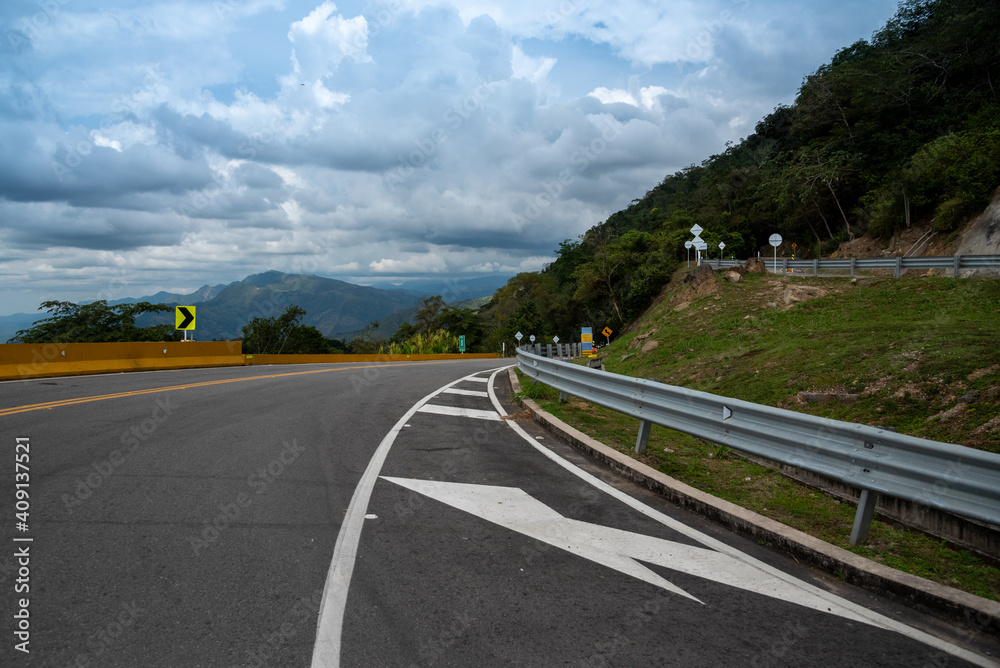 Curve of a road in the Colombian countryside on a cloudy day.