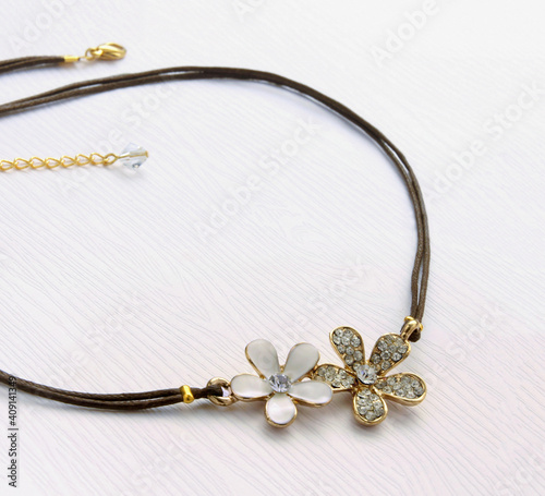 Gold flower shaped pendant with diamonds, women necklace on white background