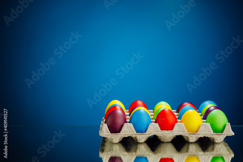Easter festive multicolor eggs carton, blue background