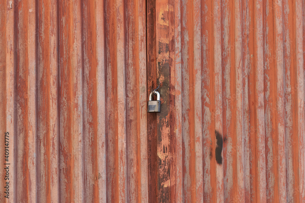Red metal door closed on the lock corrugated steel fence gate padlock garage shed in Sofia, Bulgaria, Eastern Europe Red metal door closed on the lock corrugated steel fence gate padlock garage shed in Sofia, Bulgaria, Eastern Europe