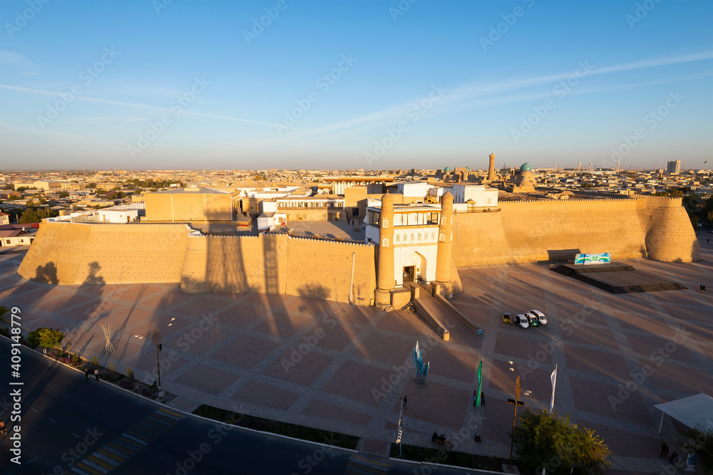 Fototapeta premium Bukhara Fortress (Ark), Uzbekistan in sunset light showing the old city wall, Po-i-Kalan (Poi Kalon) architectural complex and Kalyan minaret.