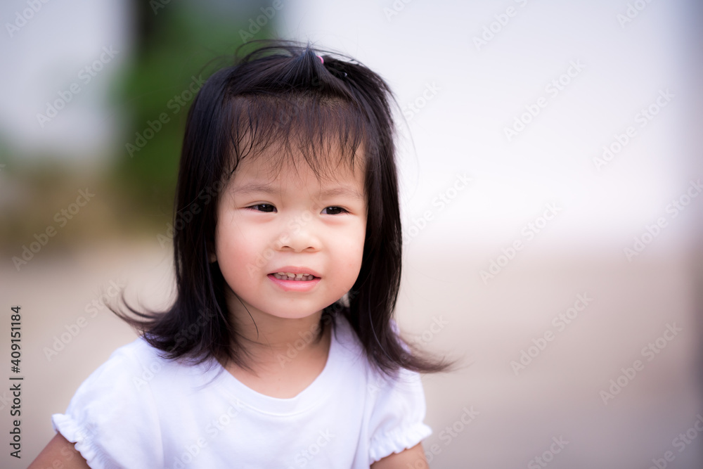 Candid adorable Asian little girl relaxing stay at home during corona virus lock down. Head shot of healthy kid girl. Happy child smiling face. Concept positive children and social distancing.