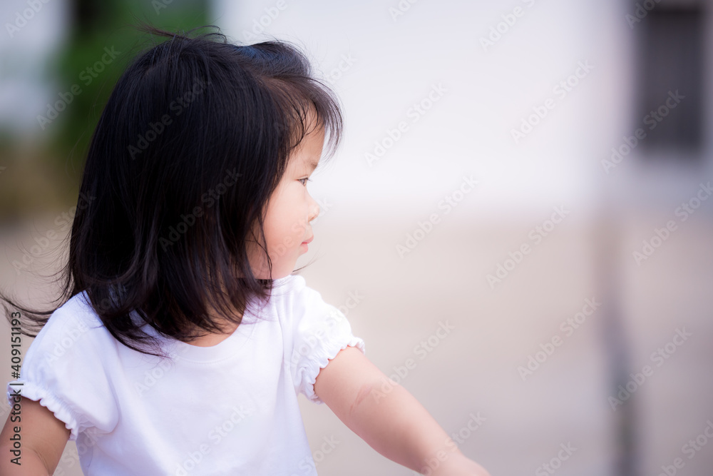 Candid adorable Asian little kid girl is wearing a white shirt, looking at the left side. Sweet smile in summer or spring. Photos in the right half of the page. Baby child age 3 - 4 years old. Candid adorable Asian little kid girl is wearing a white shirt, looking at the left side. Sweet smile in summer or spring. Photos in the right half of the page. Baby child age 3 - 4 years old.