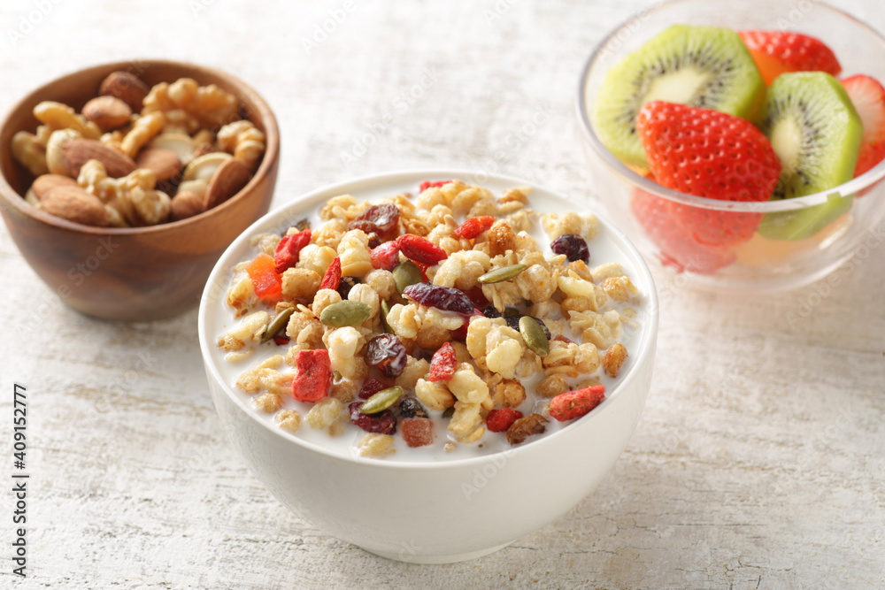 ミルクを注いだ朝食のシリアルやフレークと果物