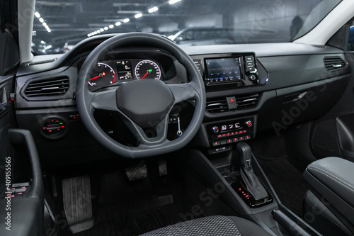 Dark car Interior - steering wheel, shift lever and dashboard, climate control, speedometer, display. Salon of a new stylish car. © Виталий Сова