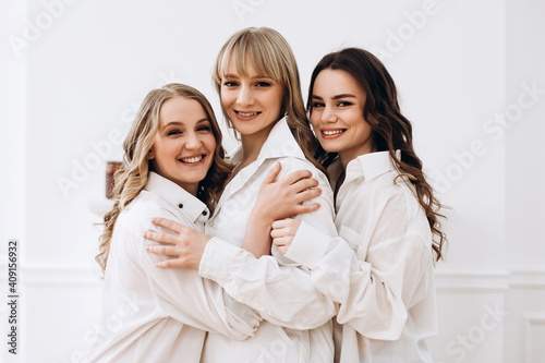 three young women hugging. Portrait of three ladies, girlfriends. 3 sisters together. Female friendship concept. 
