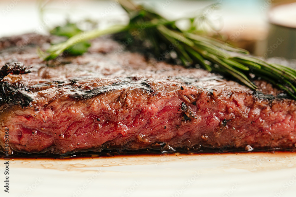 Closeup on roasted beef medium rare steak with a rosemary