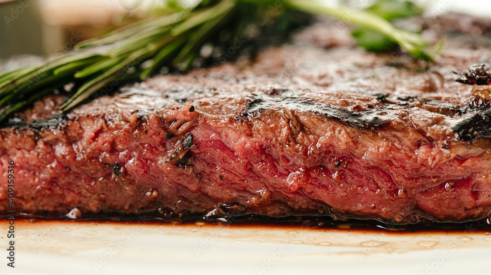 Closeup on roasted beef medium rare steak with a rosemary