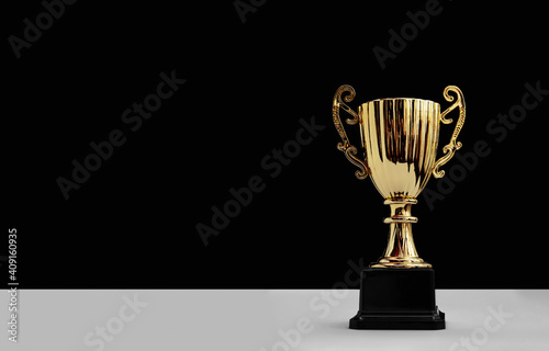 golden trophy cup with copy space on black background photo