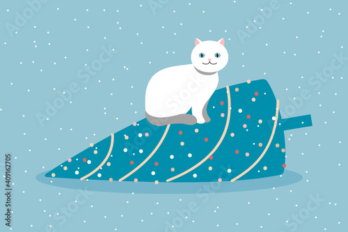 white cat sits on a fallen Christmas tree.